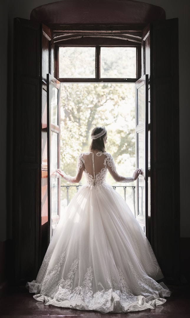 Bride in wedding dress at a window photography